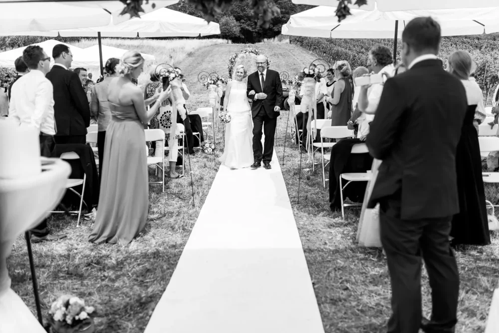Fotograf bei Einzug der Braut mit Brautvater zur freien Trauung im Weinberg zur Hochzeit bei Würzburg nahe Winzerhof Stahl