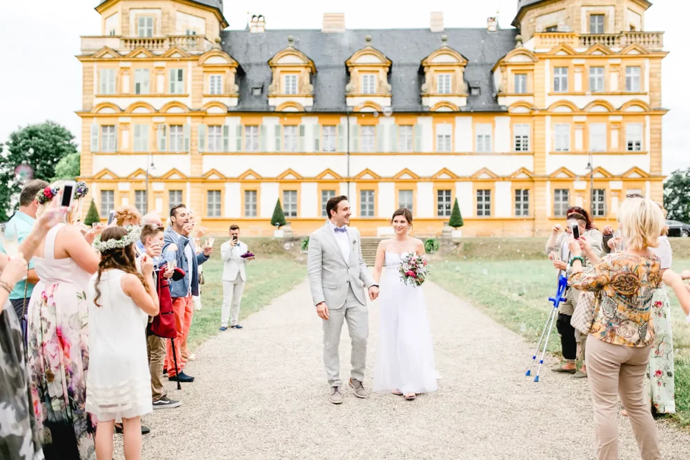 Auszug des Brautpaars mit Seifenblasen nach Standesamt zur Hochzeit mit Fotograf in Bamberg auf Schloss Seehof