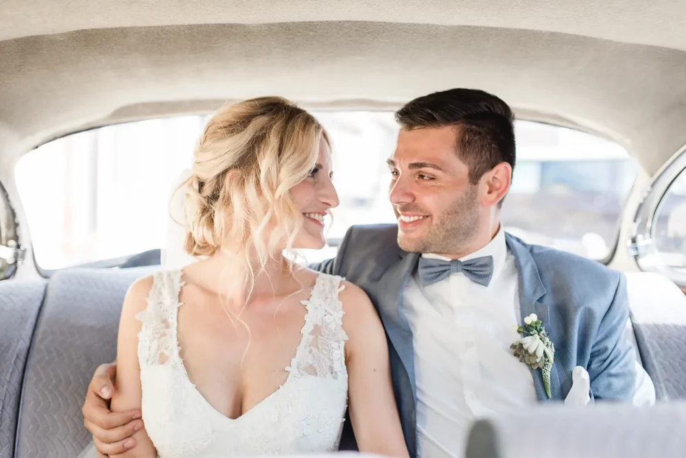 hochzeitsfotografin-freihof-prichsenstadt-054 glückliches Hochzeitspaar im Oldtimer vor Hotel Freihof