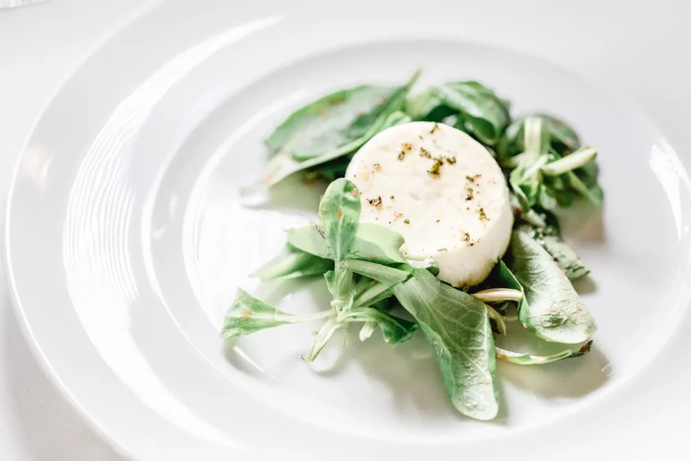 hochzeitsfotografin-freihof-prichsenstadt-106 Ziegenkäse auf Feldsalat als Vorspeise in der Eventscheune im Hotel Freihof in Prichsenstadt