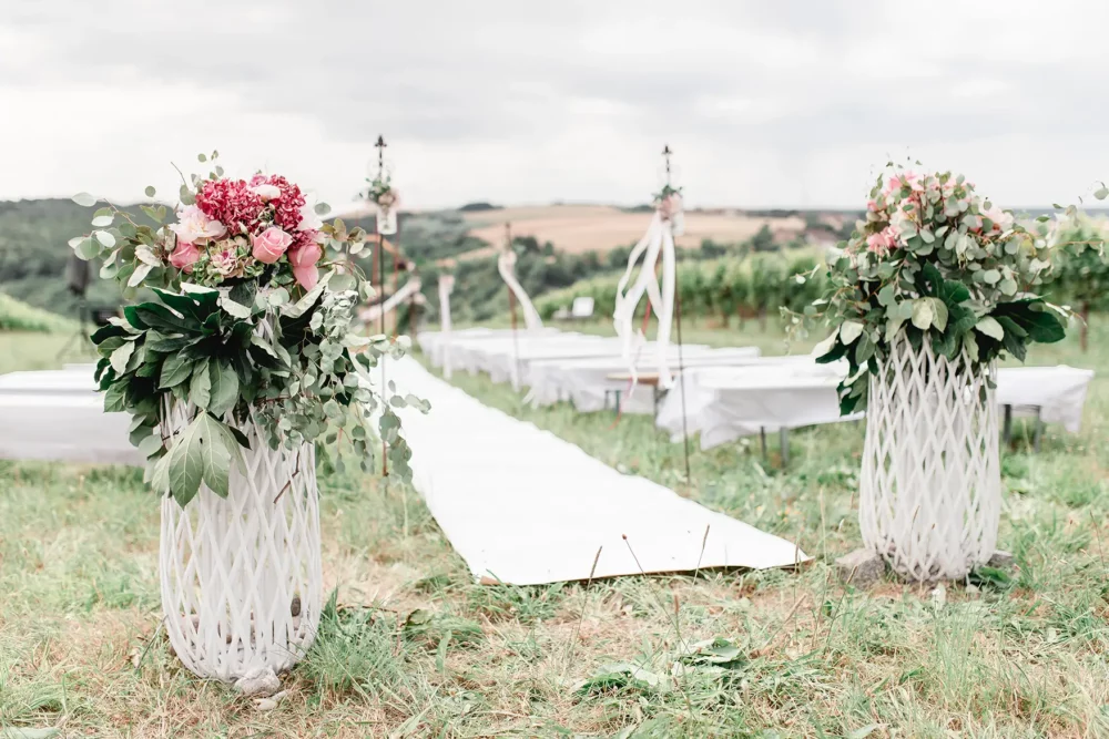oppulente Blumendeko in rosa für freie Trauung in den Weinbergen zur Hochzeit bei Würzburg