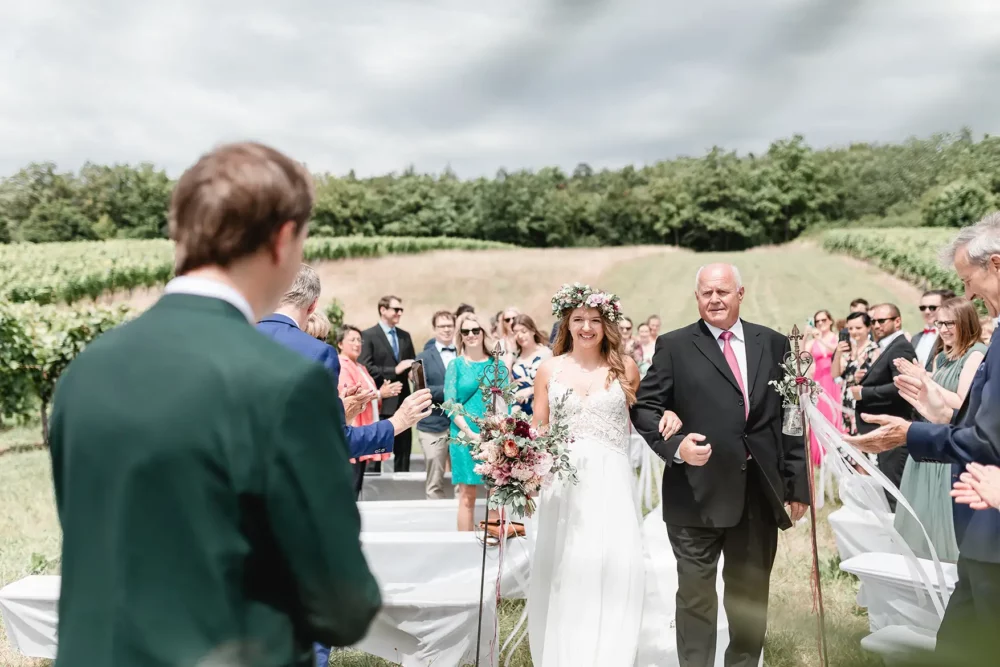 Einzug der Braut zur freien Trauung in den Weinbergen mit Brautvater zur Hochzeit bei Würzburg nahe Winzerhof Stahl