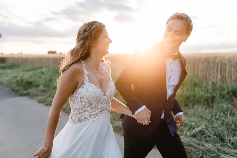Hochzeitspaar läuft in den Sonnenuntergang bei Hochzeit im Winzerhof Stahl bei Würzburg
